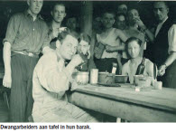Dwangarbeiders aan tafel in hun barak